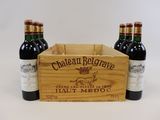trois bouteilles de vin dans une caisse en bois sur fond blanc
