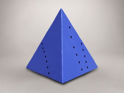 un objet bleu de forme triangulaire, percé de trous au milieu
