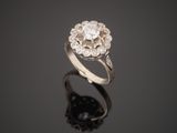 a white gold and diamond ring on a reflective surface