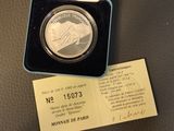 a silver coin in a blue box on a table