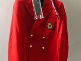 un blazer rouge suspendu à un cintre sur un mur blanc