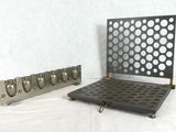 two pieces of metal with holes on them on a white surface
