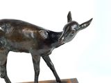 a statue of a deer that is standing on a wooden base