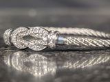 a silver ring with a knot on it on a table