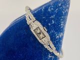 un gros plan d'une montre sertie de diamants posée sur un vase bleu
