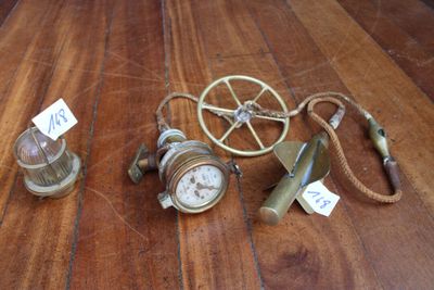 trois horloges posées sur une table en bois, accompagnées d'étiquettes