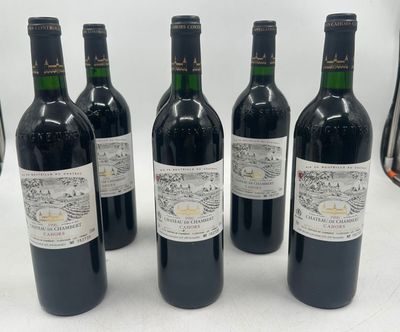 six bouteilles de vin sont alignées sur une table
