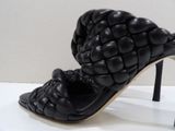 a pair of black high heeled shoes on a white table