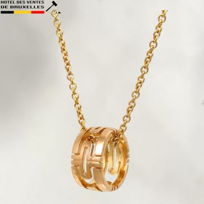 un collier plaqué or composé de trois anneaux entrelacés montés sur une chaîne