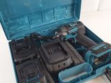 une mallette à outils bleue contenant des outils, posée sur une surface blanche
