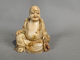 une petite figurine en ivoire sculpté représentant un Bouddha assis