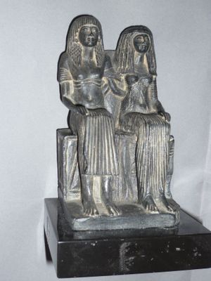 a statue of two women sitting on a bench