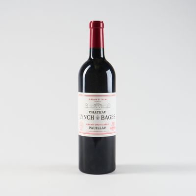 une bouteille de vin rouge posée sur une table blanche