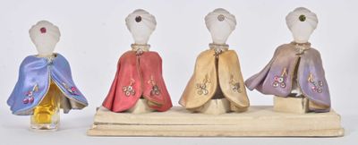 three figurines of people dressed in different colors and patterns