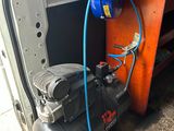un compresseur d'air et un tuyau bleu fixé à l'arrière d'une camionnette