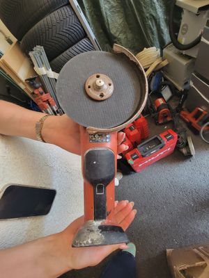 une personne qui tient une ponceuse à la main