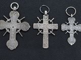 three silver crosses with crosses on them on a black background