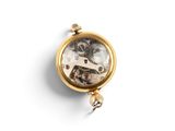 a small gold pocket watch on a white surface