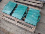 two green plastic boxes sitting on a pallet on the ground