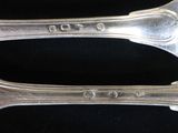 pair of silverware spoons sitting on a black surface