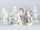 Plusieurs figurines en porcelaine, de tailles et de formes variées, sont exposées sur une table