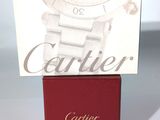 La montre Cartier est posée sur un coffret rouge