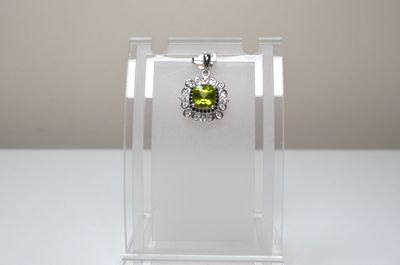 pendentif en argent sterling et péridot présenté dans un présentoir en acrylique transparent