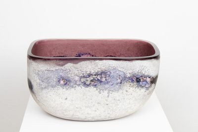 un bol blanc et violet posé sur une table blanche