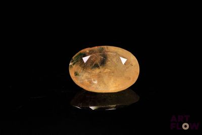 un gros plan d'un quartz jaune posé sur une surface noire