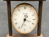 une petite horloge en bois avec des chiffres romains