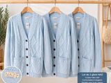 three blue sweaters hanging on a clothes rack in front of a window