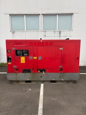 a red generator in a parking lot next to a building
