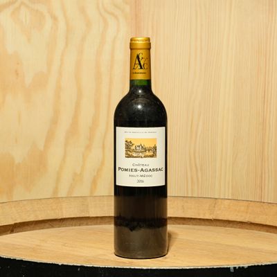 a bottle of wine sitting on top of a barrel
