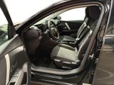 the interior of a car with the door open and the driver ' s seat down