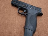 une photo d'un pistolet noir posé sur une surface marron