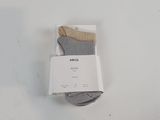 deux paires de chaussettes grises et blanches posées sur une table blanche