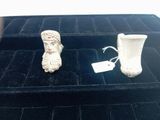 a small white vase and a small white vase on a black tray