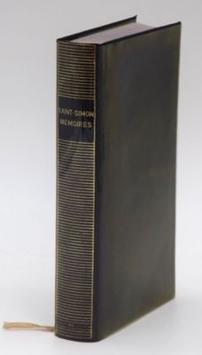 an old book is sitting on top of a white surface