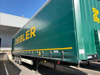une semi-remorque verte garée sur un parking