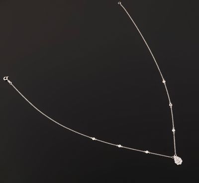 a close up of a necklace on a black surface with a black background