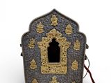 une petite boîte en métal ornée d'un motif doré