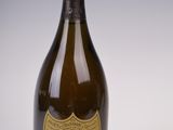 an old bottle of champagne sitting on top of a white table