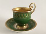 a green cup and saucer on a white table