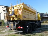 a yellow dump truck parked in front of a building
