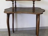 une petite table en bois surmontée de deux étagères