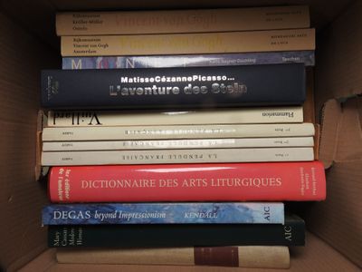 many books in a box that are stacked on top of each other