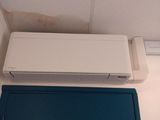 un climatiseur blanc posé sur une boîte bleue