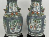 paire de vases chinois ornés de personnages, posés sur un socle