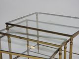 three glass tables with gold legs on a white background
