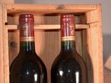 two bottles of wine sitting in a wooden box